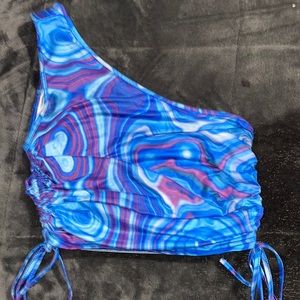 One sleeve crop top with ties to adjust the length.